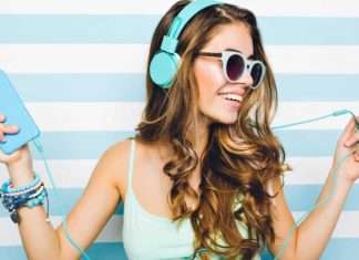 De 11 bedste websider, hvor du lovligt kan downloade gratis musik En ung kvinde med langt, bølget hår bærer et par lyseblå hovedtelefoner og holder en lyseblå enhed i den ene hånd. Hun har flere armbånd på håndleddet og står foran en baggrund med vandrette lyseblå og hvide striber.