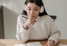 9 YouTube-kanaler, du kan streame, mens du studerer En pige med høretelefoner, der studerer ved sit skrivebord.