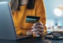 Hvordan fungerer Shein Wallet, og kan den hackes? Pigen foran en bærbare computer med et kreditkort i hånden.