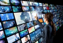 En pige foran en stor skærm, der består af mange små videoskærme