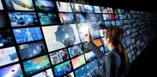 En pige foran en stor skærm, der består af mange små videoskærme