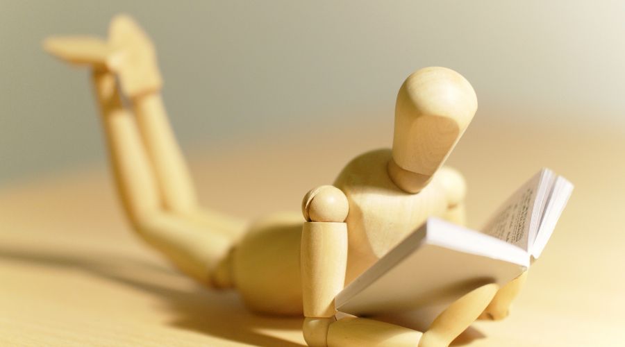 9 grunde til, at sociale medier faktisk er gode for dig 3 En træmand ligger på gulvet med en bog.