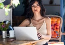 En pige ved et skrivebord foran en bærbar computer