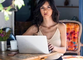 En pige ved et skrivebord foran en bærbar computer