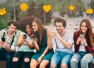 9 grunde til, at sociale medier faktisk er gode for dig Fem unge mennesker sidder på en bænk med smartphones