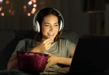 De 8 bedste YouTube-kanaler med explainer-videoer Pige med høretelefoner foran en laptop med popcorn på bordet