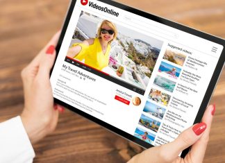 De 5 bedste YouTube Playlist Downloadere til at hente videoer i massevis En tablet med en videoside på skærmen i kvinders hænder