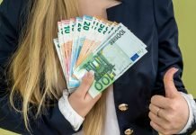 En pige holder en vifte med eurosedler.