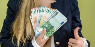 En pige holder en vifte med eurosedler.