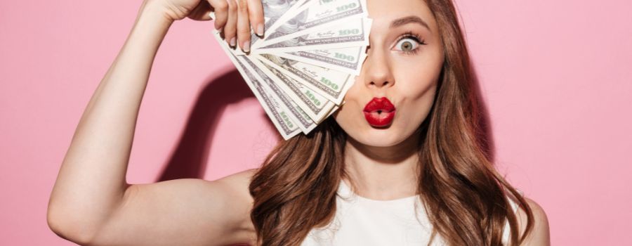 Pigen dækker sit højre øje med en vifte af dollars