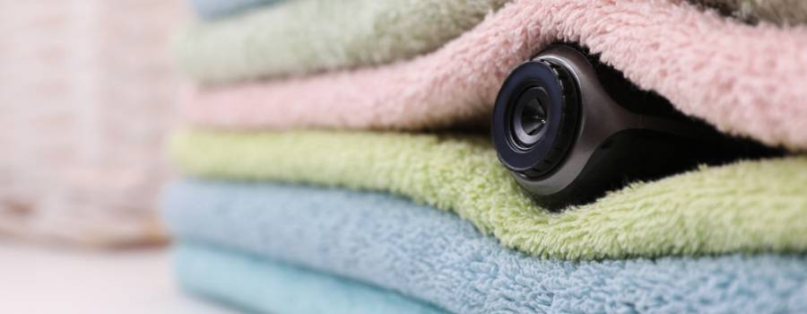 Et videokamera ligger i en stak håndklæder