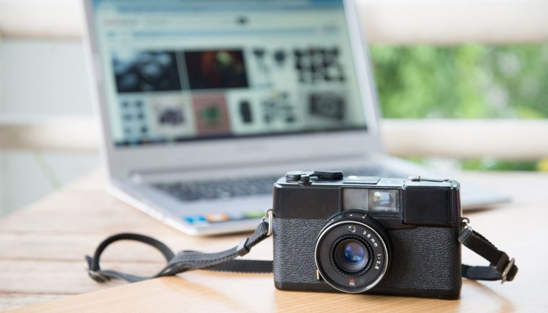 Kameraet ligger på et bord med en bærbar computer åben i baggrunden