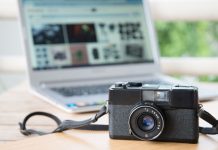 Kameraet ligger på et bord med en bærbar computer åben i baggrunden
