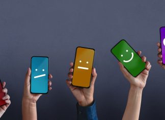 iPhone vs. Android: Hvad er det rigtige for dig? Fem hænder rakte op med smartphones, hvis skærme viser forskellige smileys på forskellige farvede baggrunde