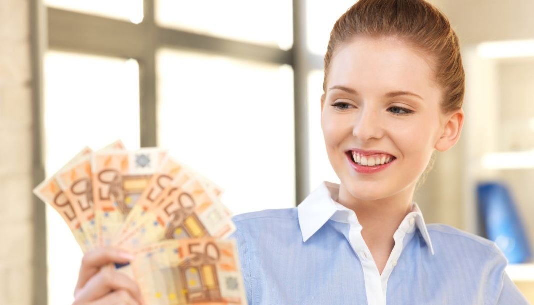 Pigen holder 50 euro-sedler med en vifte.