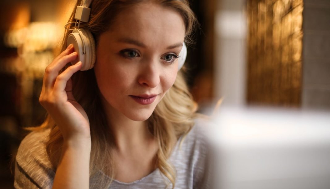 En pige med hovedtelefoner sidder foran en skærm