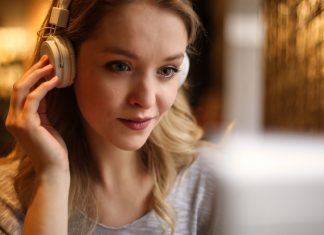 Sådan bruger du binaurale beats til bedre koncentration og fokus på arbejdet En pige med hovedtelefoner sidder foran en skærm