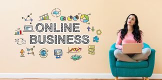 En pige sidder i en stol med en bærbar computer, og ved siden af på væggen er der et skilt: online business