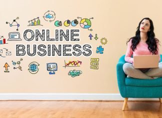 En pige sidder i en stol med en bærbar computer, og ved siden af på væggen er der et skilt: online business