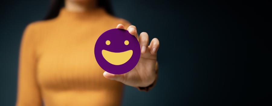 Pigen viser en glad smiley på sin udstrakte hånd