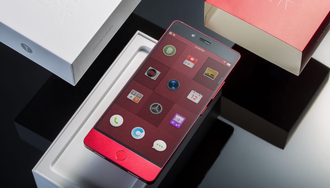 Den tændte Android-smartphone ligger på kassen