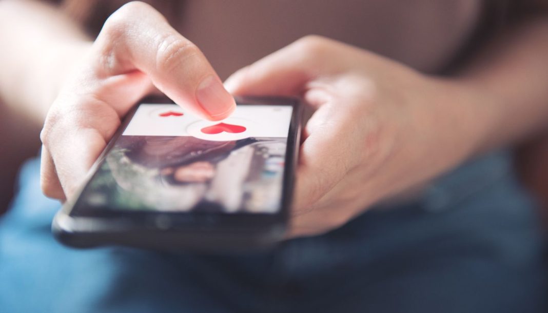 dating-app En pige holder en smartphone med en dating-app åben.