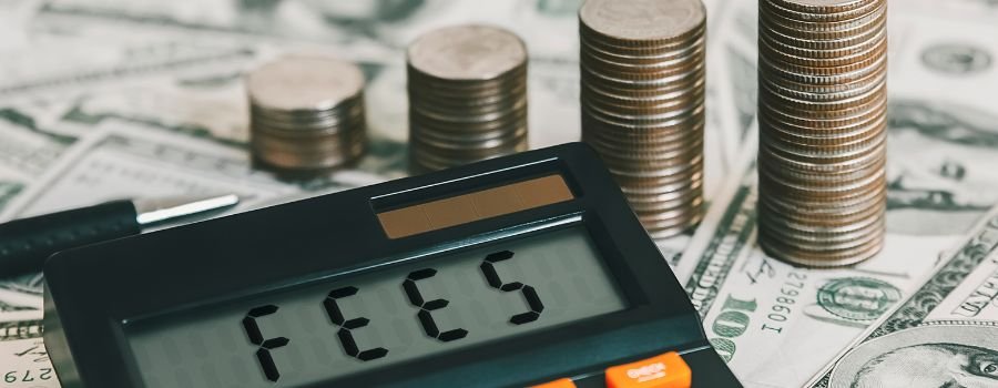 6 måder, hvorpå du kan miste dine penge ved at bruge kryptobørser, og hvordan du undgår dem 6 En lommeregner med fees skrevet på skærmen ligger på dollarsedler ved siden af stakke af mønter