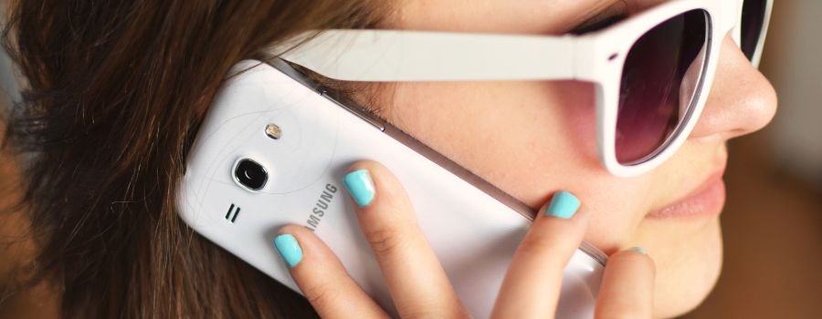 Pigen holder en hvid Samsung-telefon ved sit øre