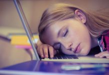 Hvad er bedst? At slukke din bærbare eller sætte den i dvale? En pige sover på et laptop-tastatur.