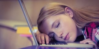 En pige sover på et laptop-tastatur.