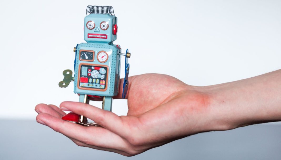 trading-bots En lille legetøjsrobot i en kvindes håndflade