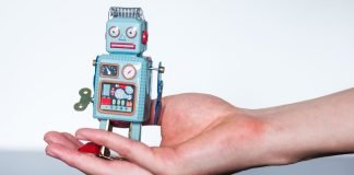 En lille legetøjsrobot i en kvindes håndflade
