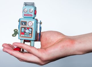 En lille legetøjsrobot i en kvindes håndflade