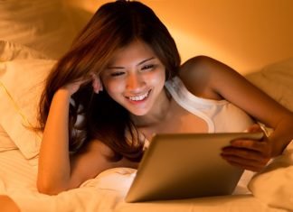 De 14 bedste sider til at se film gratis Asiatisk pige med en tablet i hænderne ligger i sengen