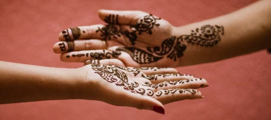 To kvindehænder dekoreret med mehendi