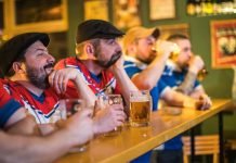 Koncentrerede mænd ser live sportskamp i baren