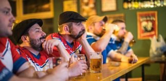 Koncentrerede mænd ser live sportskamp i baren