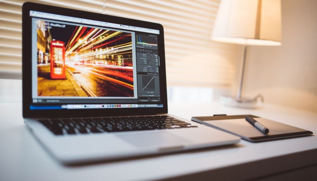 lightroom Apple MacBook Pro laptop på bordet med Lightroom åben på skærmen.