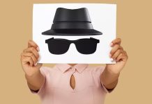 En person holder et ark med en tegning af en hat og solbriller, der symboliserer inkognito-tilstand