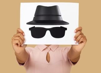 En person holder et ark med en tegning af en hat og solbriller, der symboliserer inkognito-tilstand