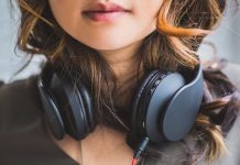 Brug denne app i stedet for YouTubes musikhjemmeside En pige med sorte hovedtelefoner rundt om halsen.