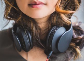 En pige med sorte hovedtelefoner rundt om halsen.