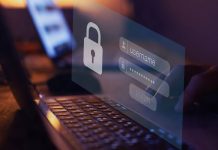 En nærbillede af en persons hænder, der taster et brugernavn og en adgangskode ind på en bærbar computer. Skærmen viser et login-vindue med et ikon af en lås.