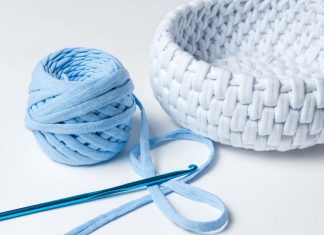 7 bedste gratis hjemmesider til gør-det-selv kunst og håndværk En hæklenål, et nøgle lyseblåt garn og en hæklet hvid kurv.