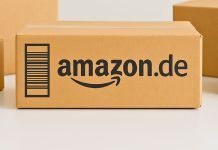 Troede du, det var et godt tilbud? Sandheden om Amazons priser vil overraske dig Amazon.de-pakken står centralt på et bord, omgivet af andre neutrale papkasser. Baggrunden er lys og enkel.