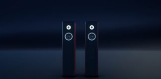 To sorte, slanke hi-fi-højttalere med hvide ringe omkring enhederne står side om side i et mørkt rum.